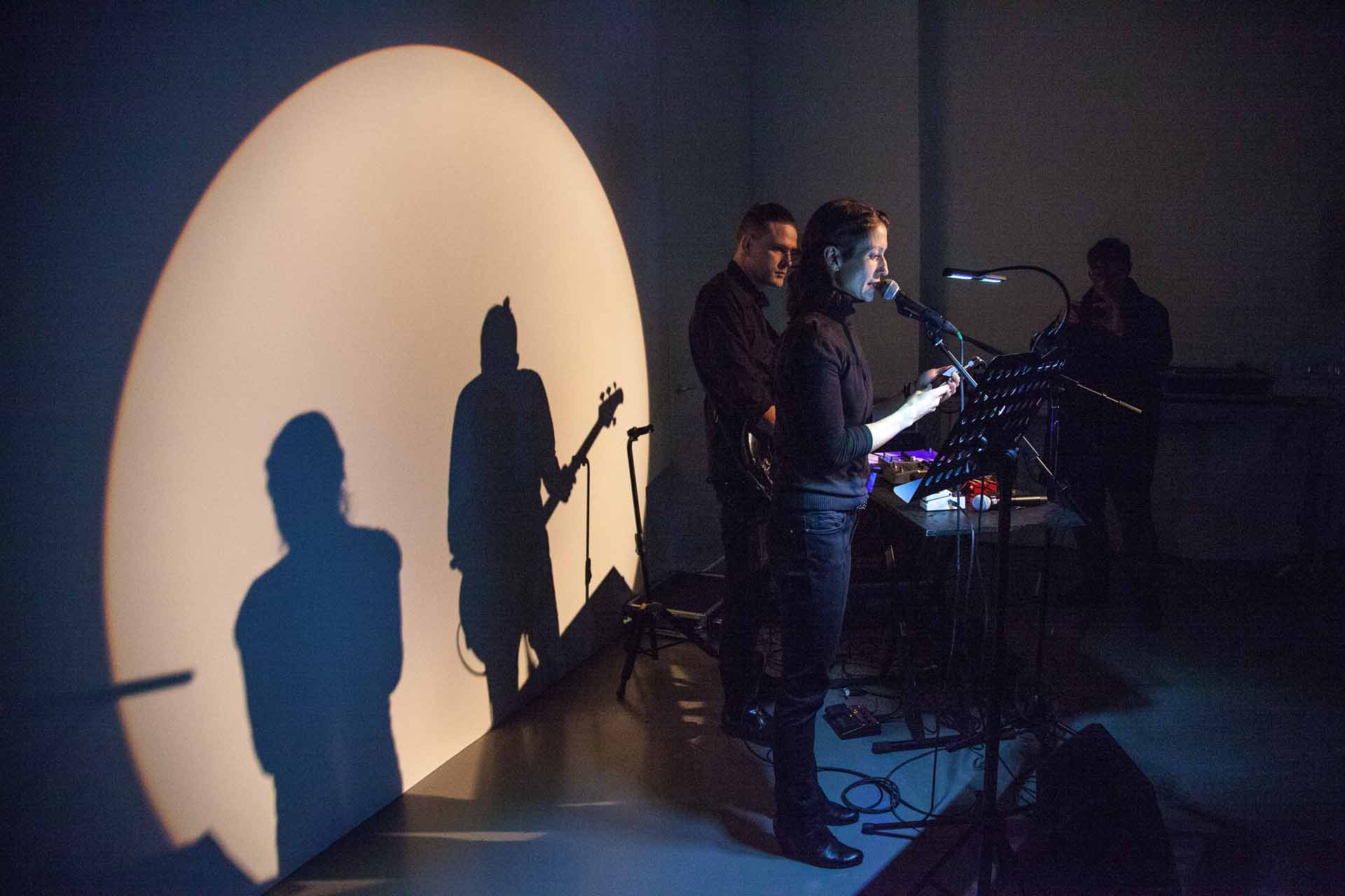 Zielinski.Photography - Images of artworks and culture - Berlin A group of people standing in front of a large shadow during a performance.