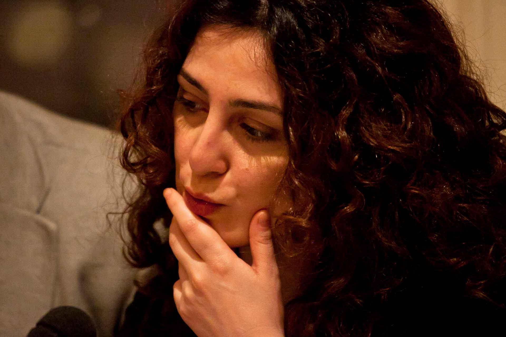Zielinski.Photography - Images of artworks and culture - Berlin A woman with curly hair is performing at a microphone during a music artwork.