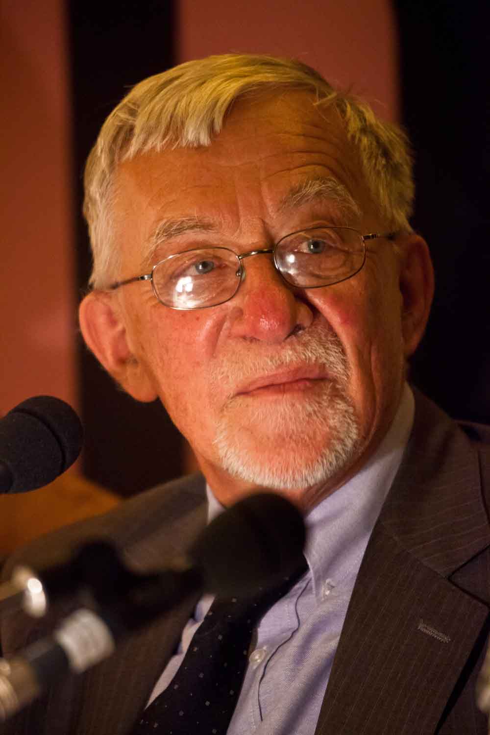 Zielinski.Photography - Images of artworks and culture - Berlin Zielinski, an older man in a suit and tie, is speaking into a microphone while his artworks are captured through photography.
