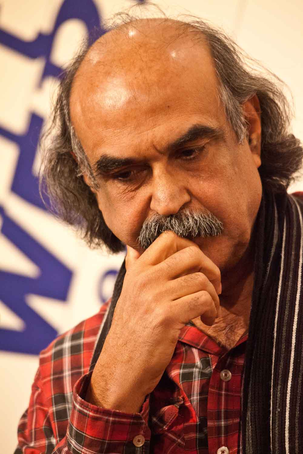 Zielinski.Photography - Images of artworks and culture - Berlin Zielinski, a man in a plaid shirt, deep in thought with his hand on his chin creating mesmerizing artworks.