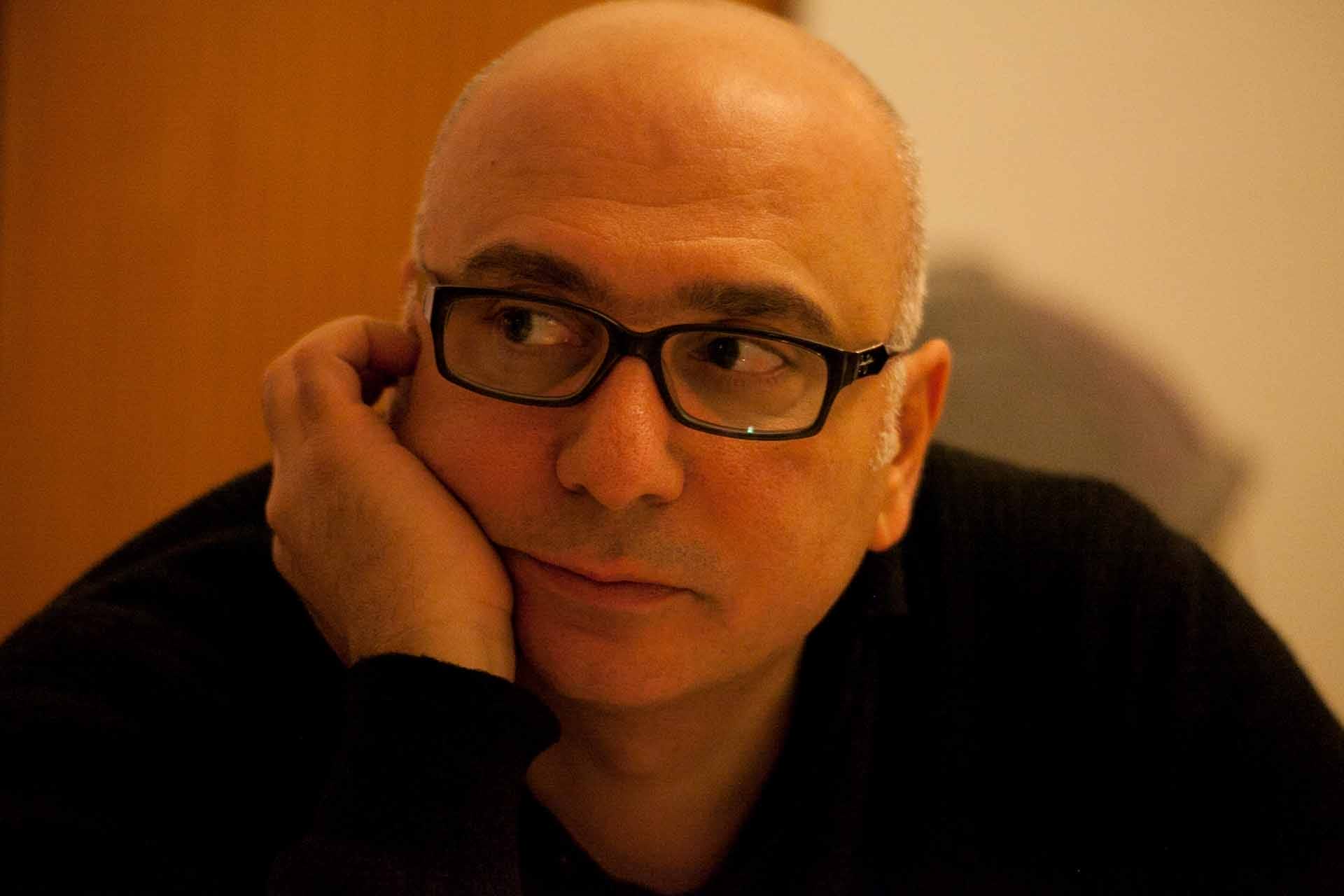 Zielinski.Photography - Images of artworks and culture - Berlin A bald man, wearing glasses and a black sweater, captivates the audience with his engaging performance in the realm of literature.