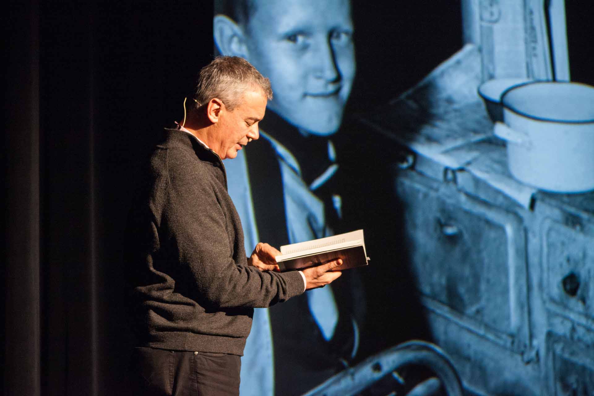 Zielinski.Photography - Images of artworks and culture - Berlin A man engrossed in literature, reading a book in front of a projection displaying mesmerizing artworks by Zielinski.