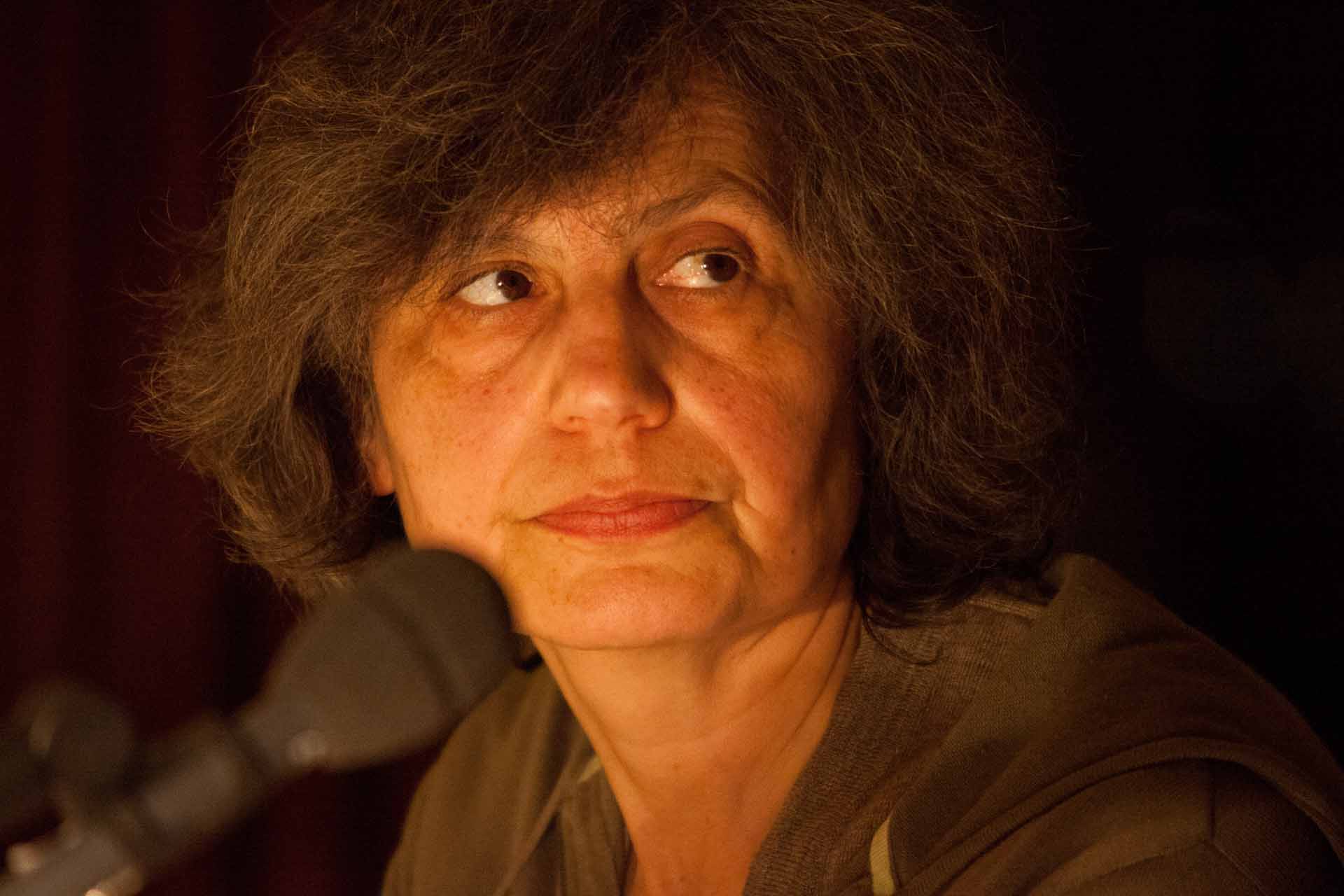 Zielinski.Photography - Images of artworks and culture - Berlin A woman is sitting in front of a microphone, passionately delivering her captivating poetry accompanied by soul-stirring melodies.