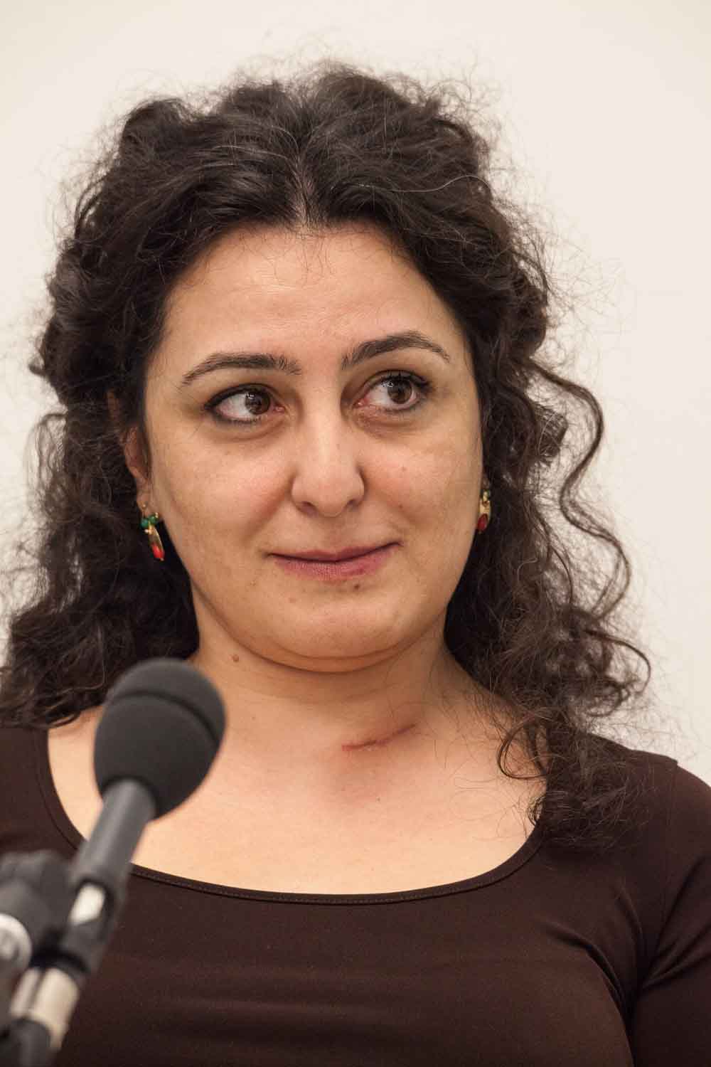 Zielinski.Photography - Images of artworks and culture - Berlin A woman with curly hair is giving a passionate performance as she speaks into a microphone.