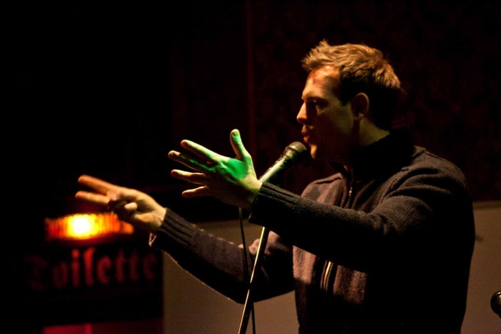 Zielinski.Photography - Images of artworks and culture - Berlin Zielinski is speaking into a microphone in front of a crowd.