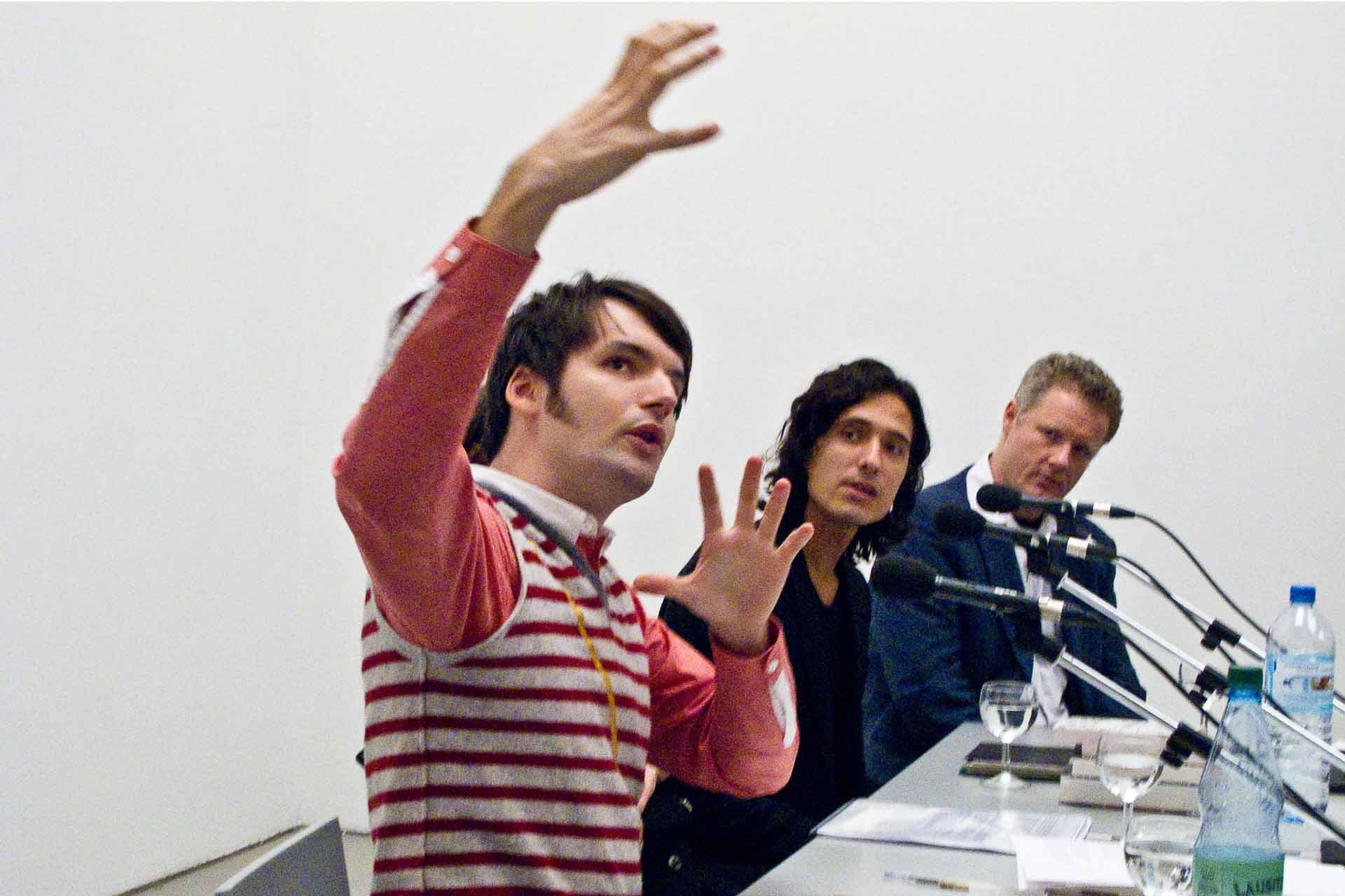 Zielinski.Photography - Images of artworks and culture - Berlin Three men, including Zielinski, engaged in fine art photography, sit at a table with microphones in front of them.