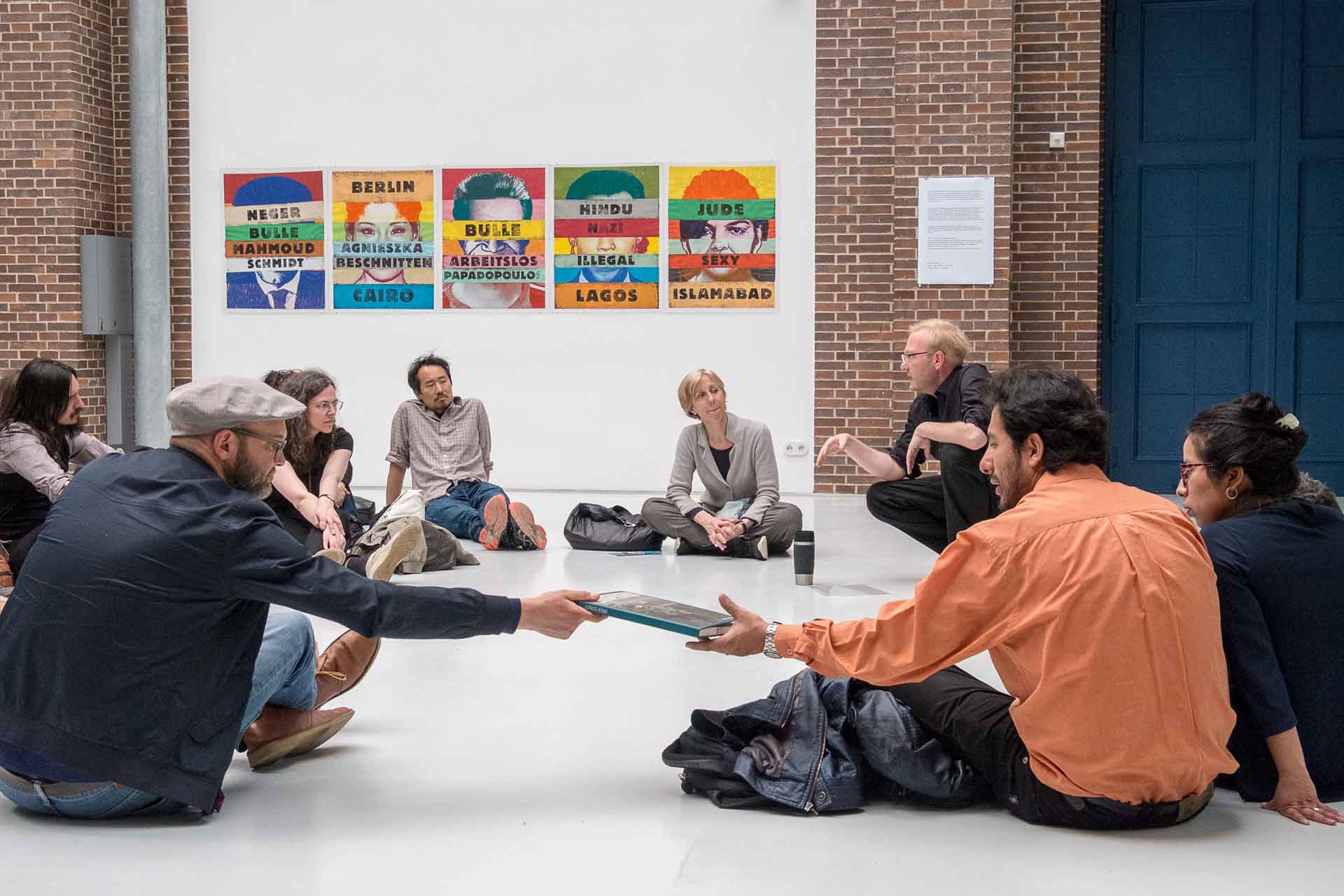 Zielinski.Photography - Images of artworks and culture - Berlin Zielinski and a group of people sitting on the floor in an art gallery, surrounded by performance artworks.