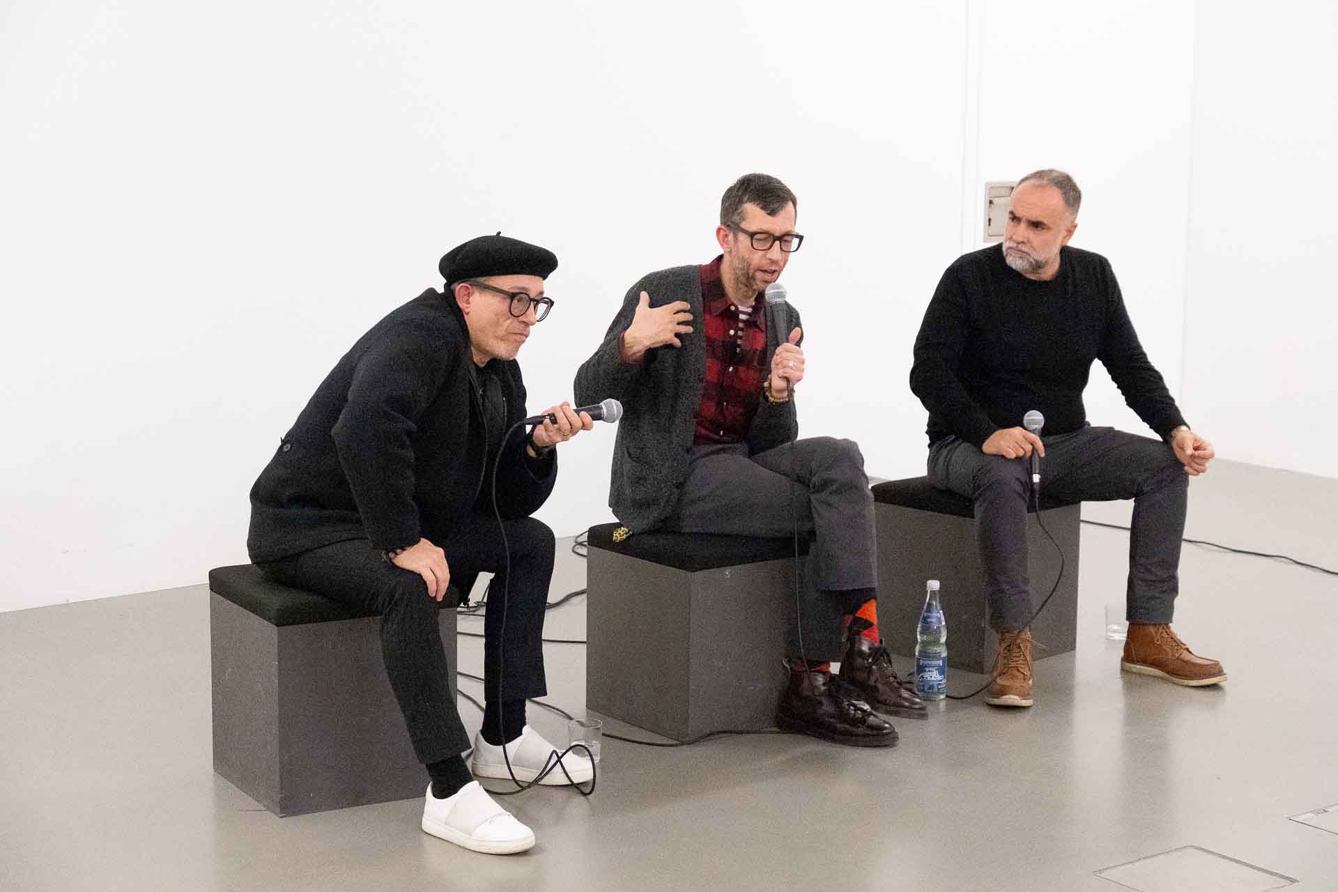 Zielinski.Photography - Images of artworks and culture - Berlin Three men delivering a literary performance in a room with microphones.