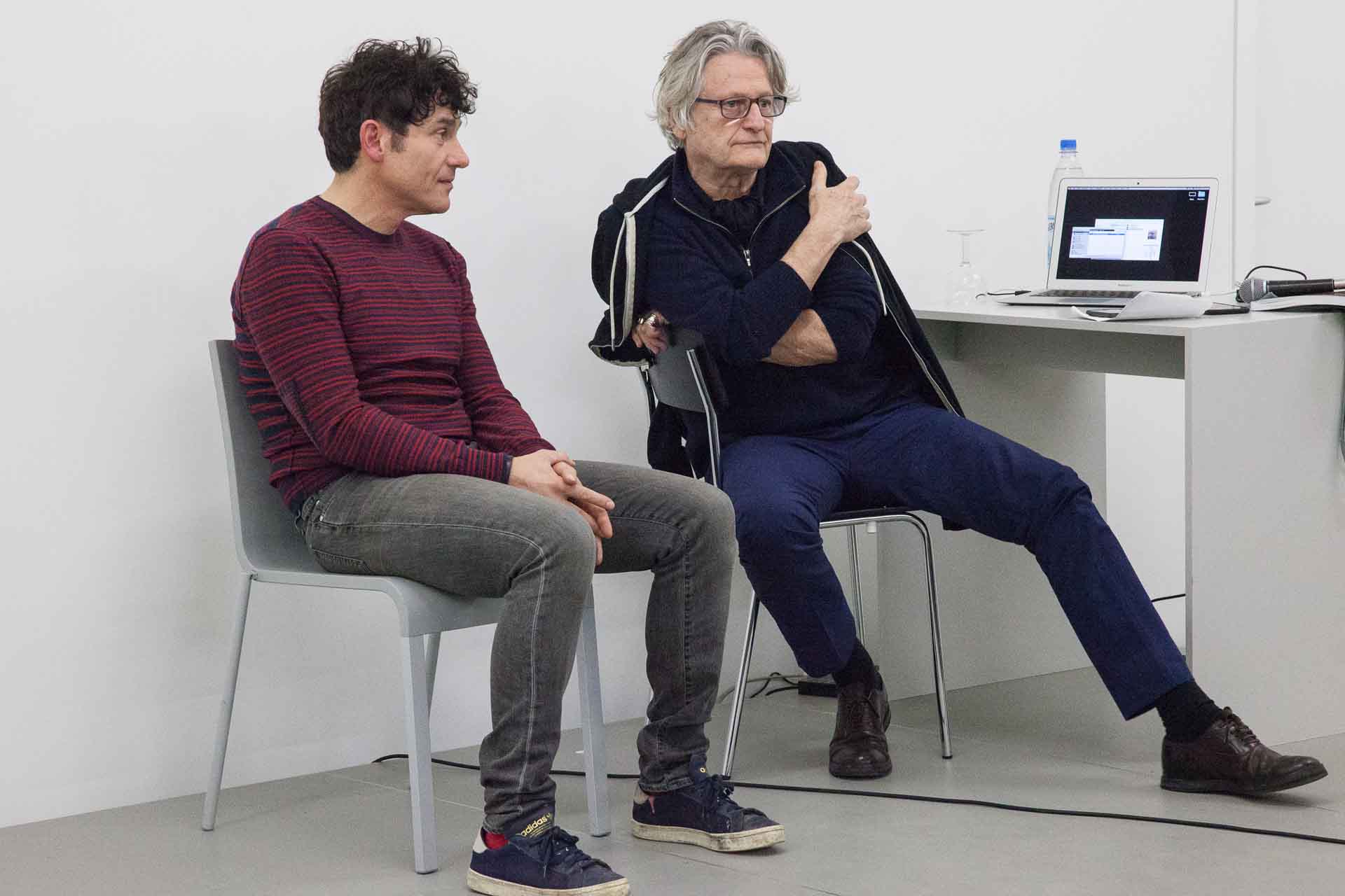 Zielinski.Photography - Images of artworks and culture - Berlin Two men sitting on chairs in front of a laptop, engaged in the performance of a task while documenting their progress.