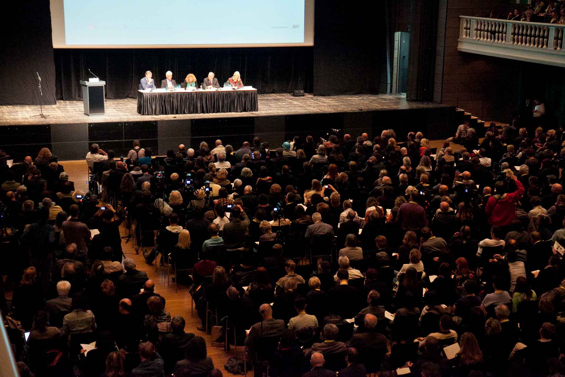 Zielinski.Photography - Images of artworks and culture - Berlin A large group of people gathered for a photography exhibition in a large auditorium.