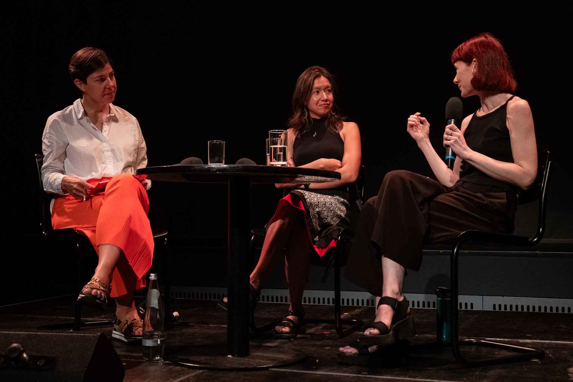Zielinski.Photography - Images of artworks and culture - Berlin Three women engaged in a stage performance, conversing with each other.