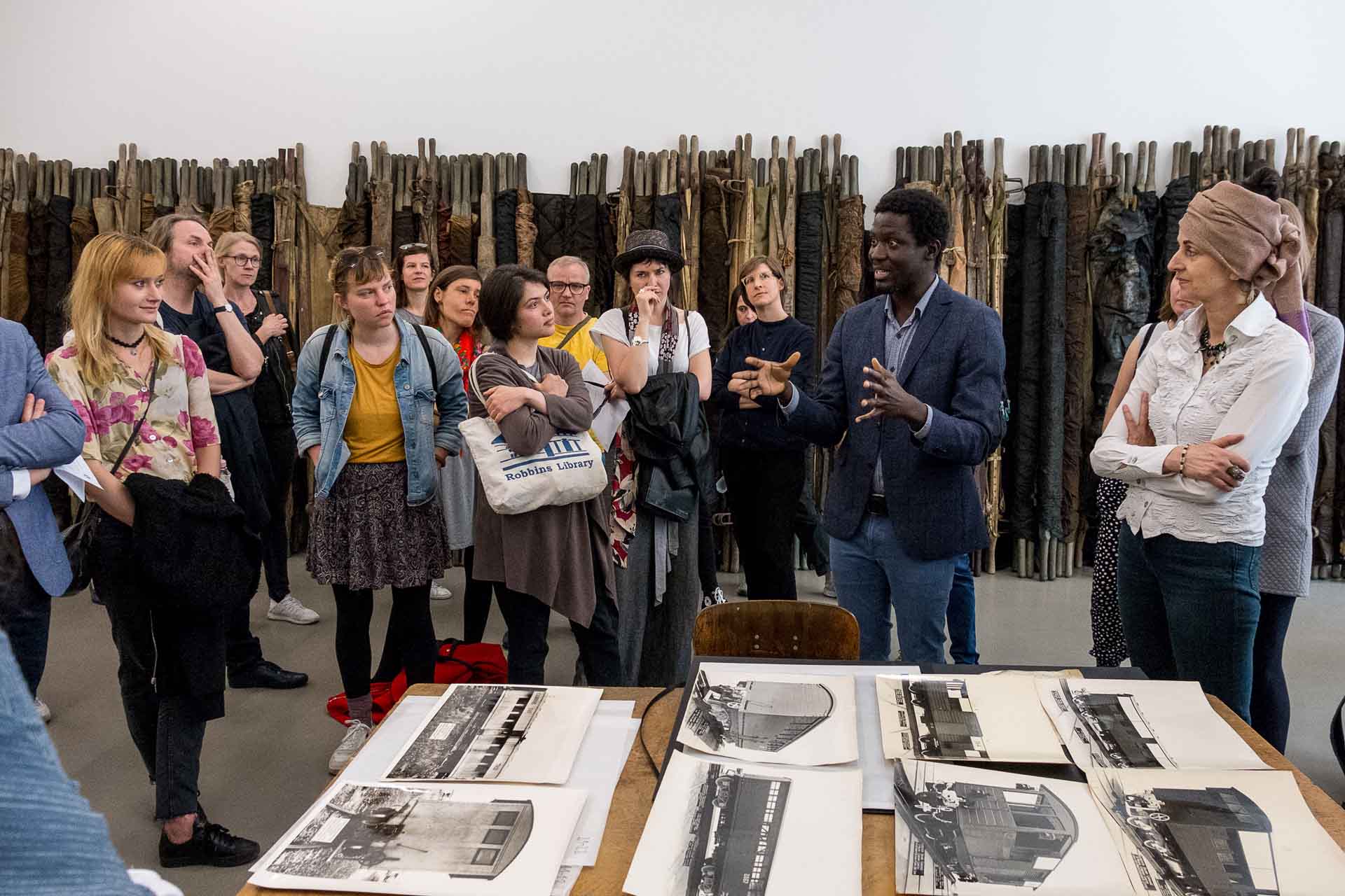 Zielinski.Photography - Images of artworks and culture - Berlin Zielinski and a group of people standing around a table with photography exhibition photos.