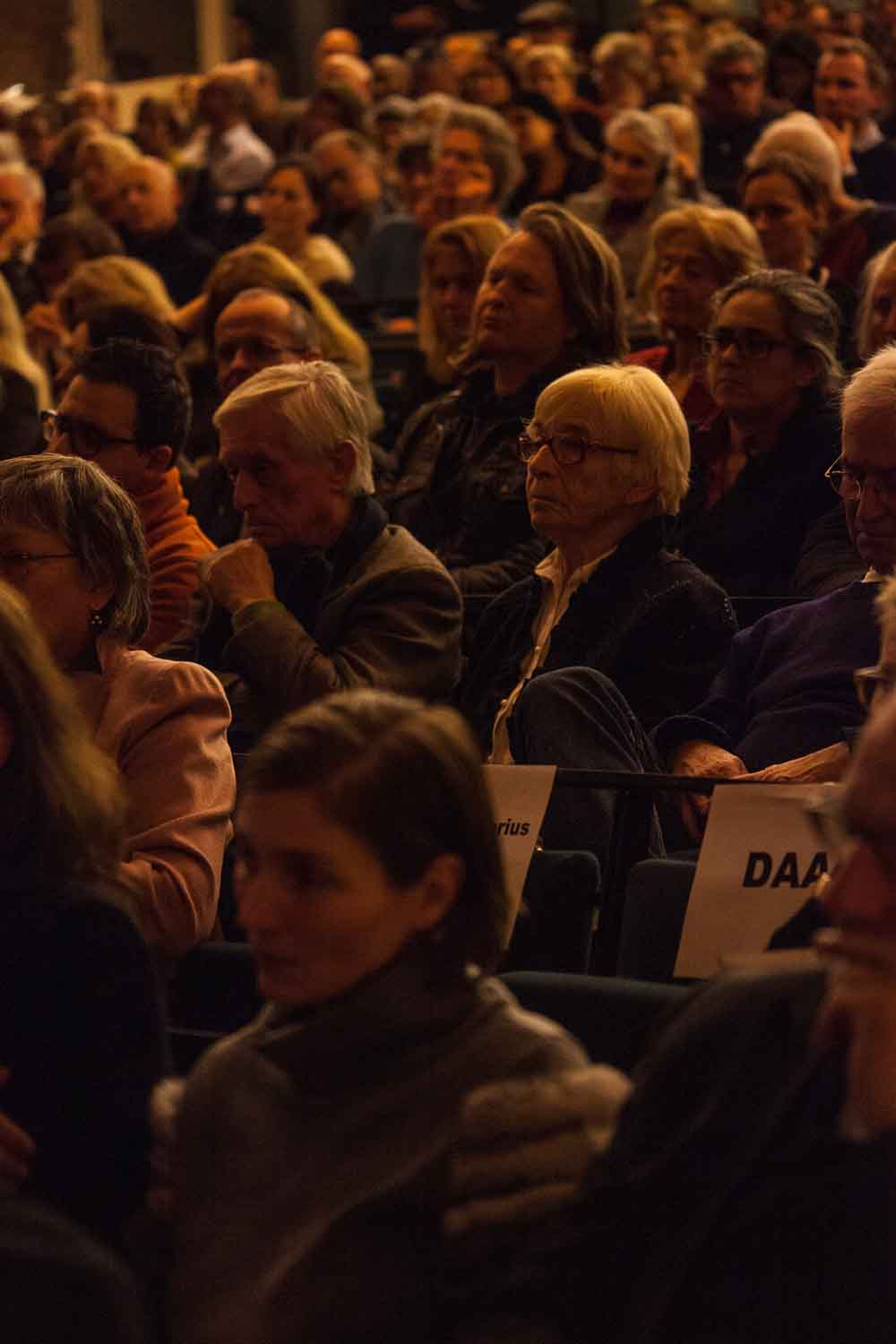 Zielinski.Photography - Images of artworks and culture - Berlin A crowd of people enraptured by a performance at an auditorium, captured through the lens of photography.