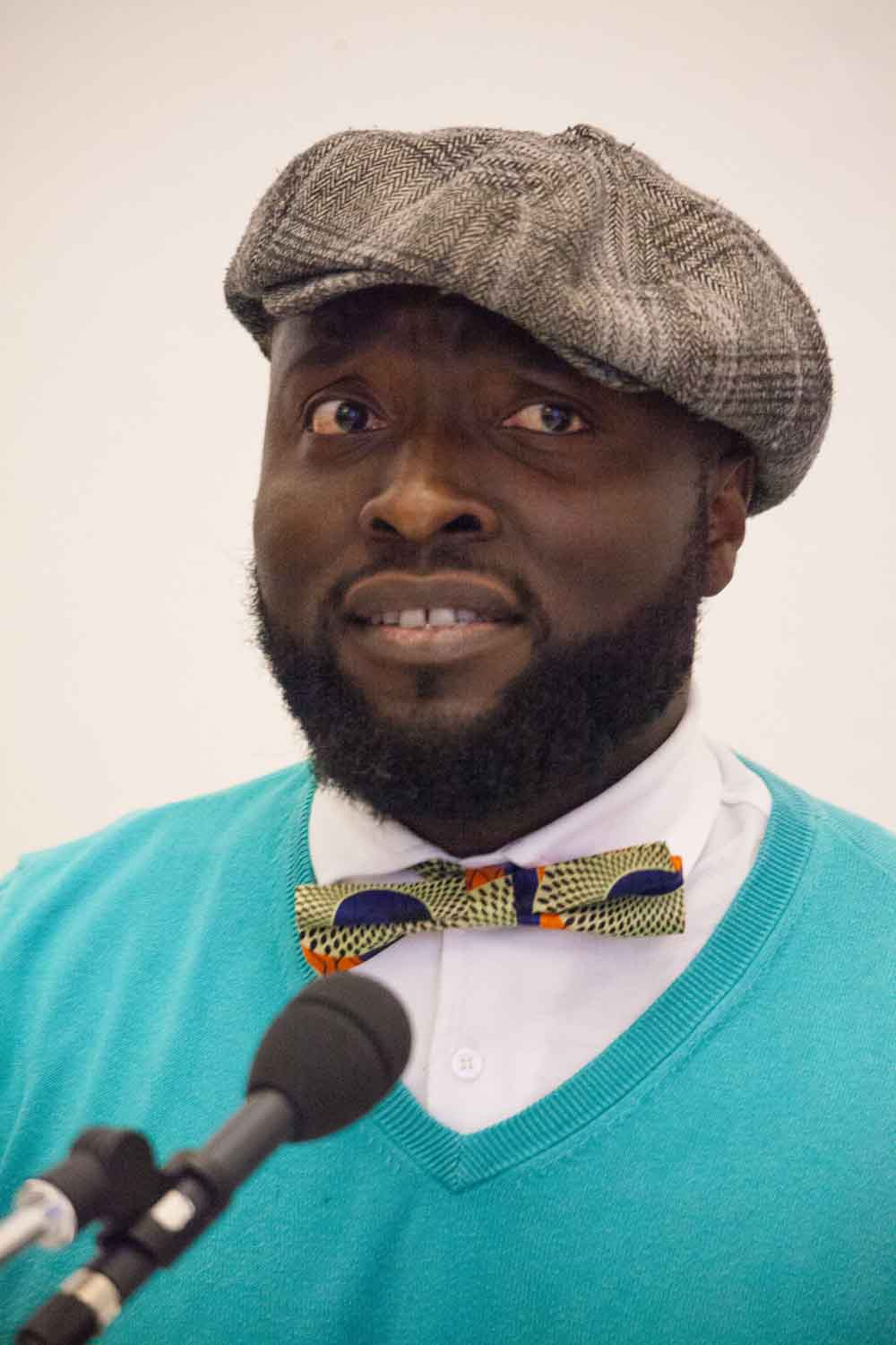 Zielinski.Photography - Images of artworks and culture - Berlin Zielinski, an artist, captures the essence of a man in a hat and bow tie speaking into a microphone through his captivating photography artworks.