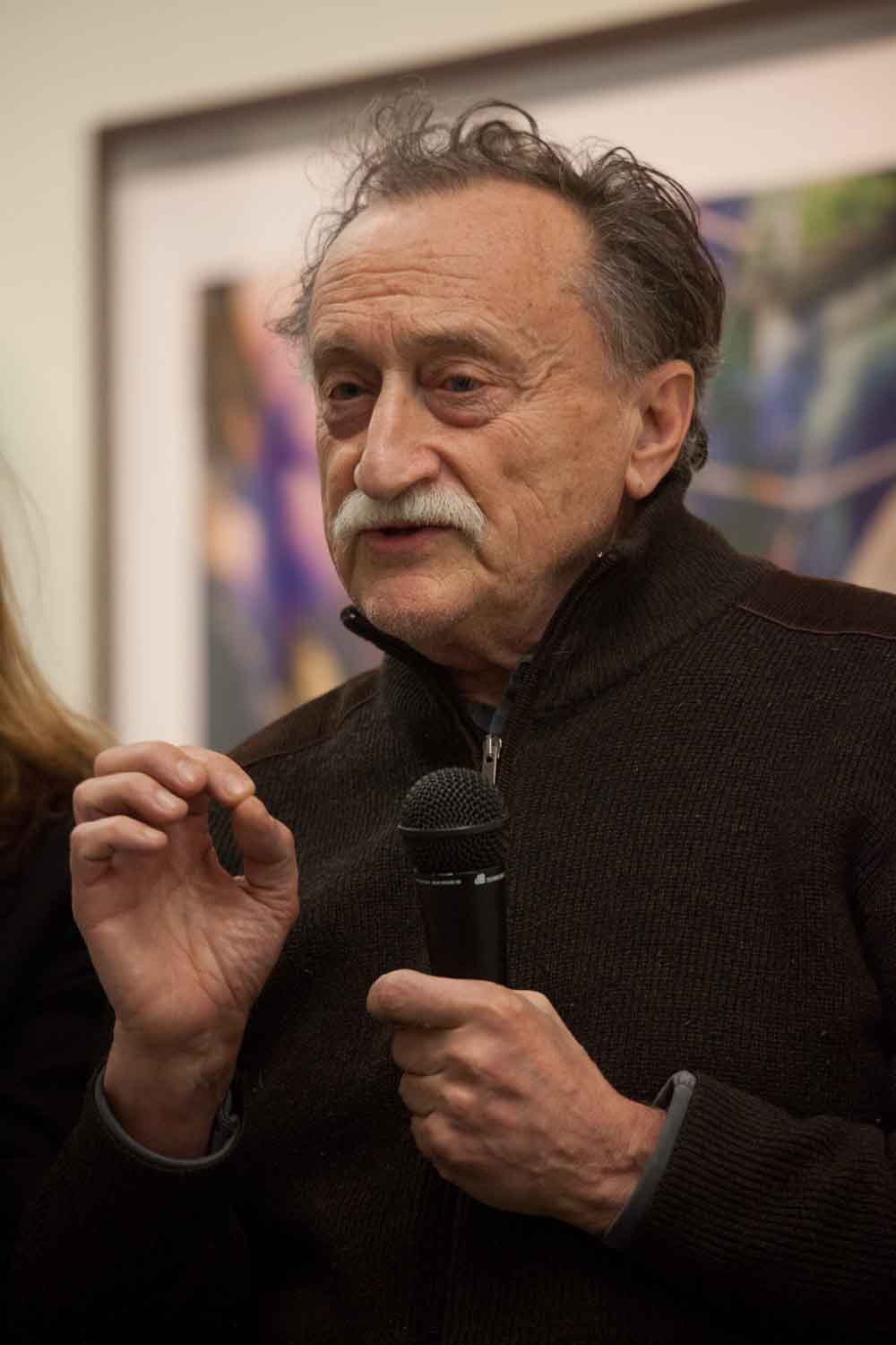Zielinski.Photography - Images of artworks and culture - Berlin A man and woman conducting a performance in front of an exhibition, microphone in hand for documentation purposes.