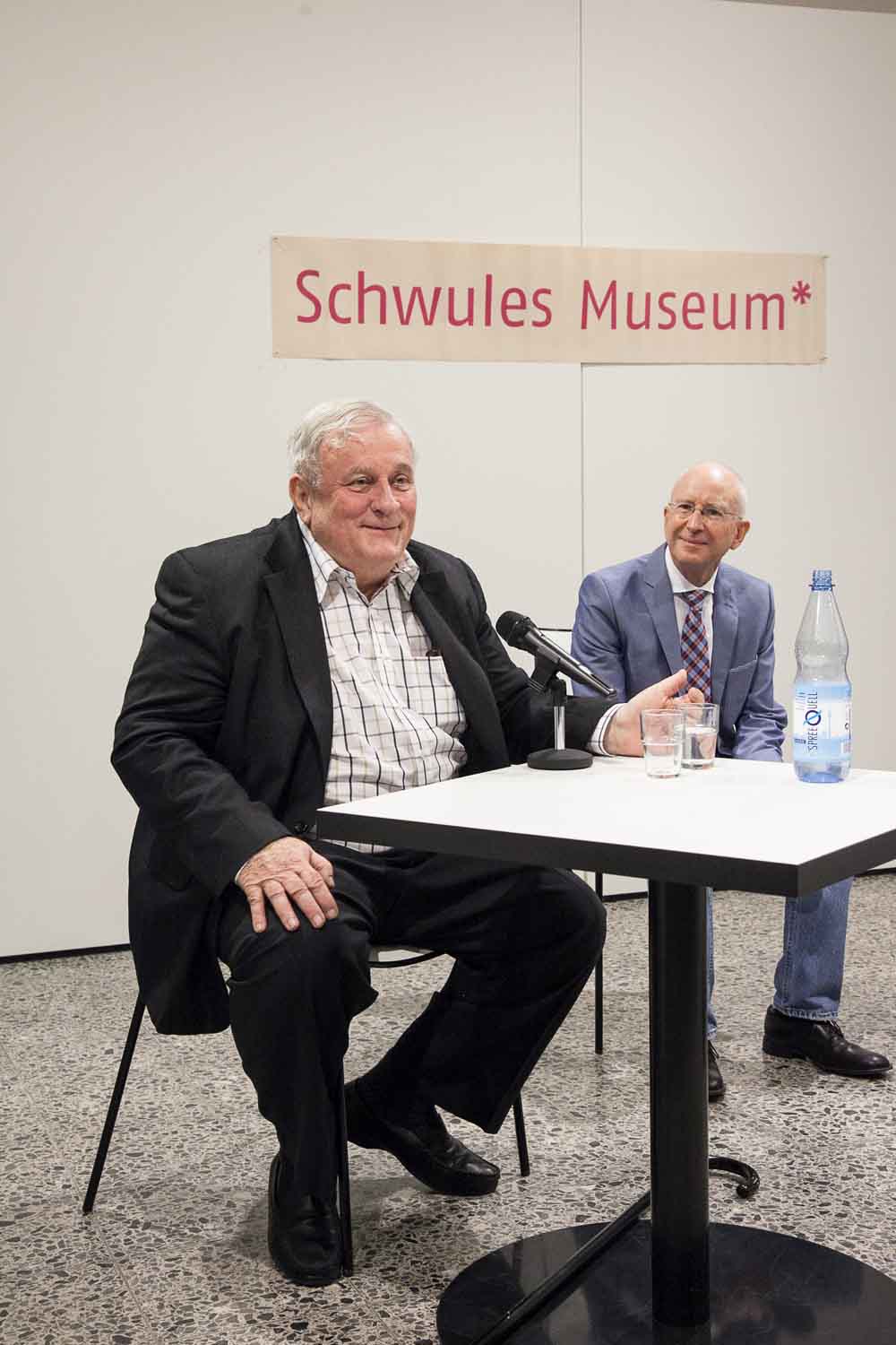 Zielinski.Photography - Images of artworks and culture - Berlin Two men sitting at a table discussing music, with microphones in front of them.