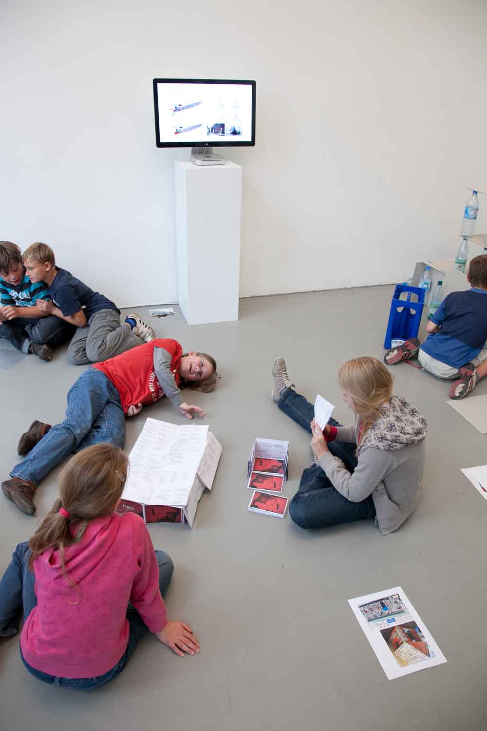 Zielinski.Photography - Images of artworks and culture - Berlin A group of Zielinski artworks depicting children laying on the floor in front of a tv, presenting a mesmerizing performance.